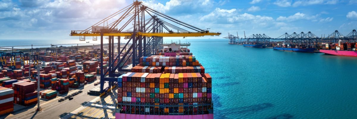 Aerial view of cargo ship and cargo container in harbor.